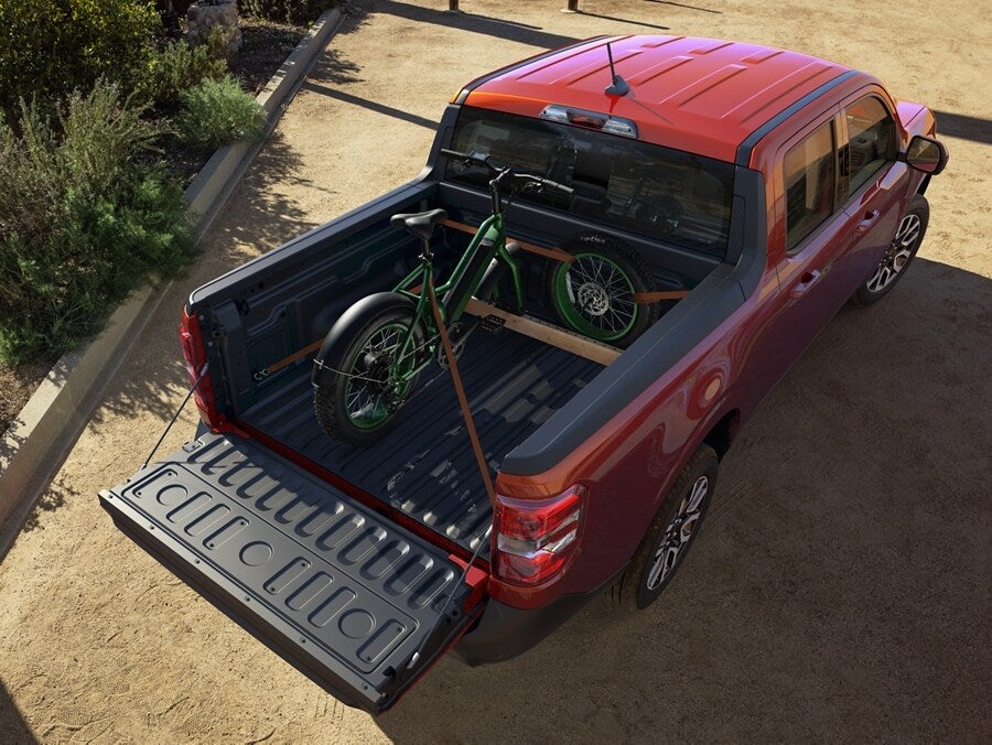 the bed of a red truck with a bicycle in it
