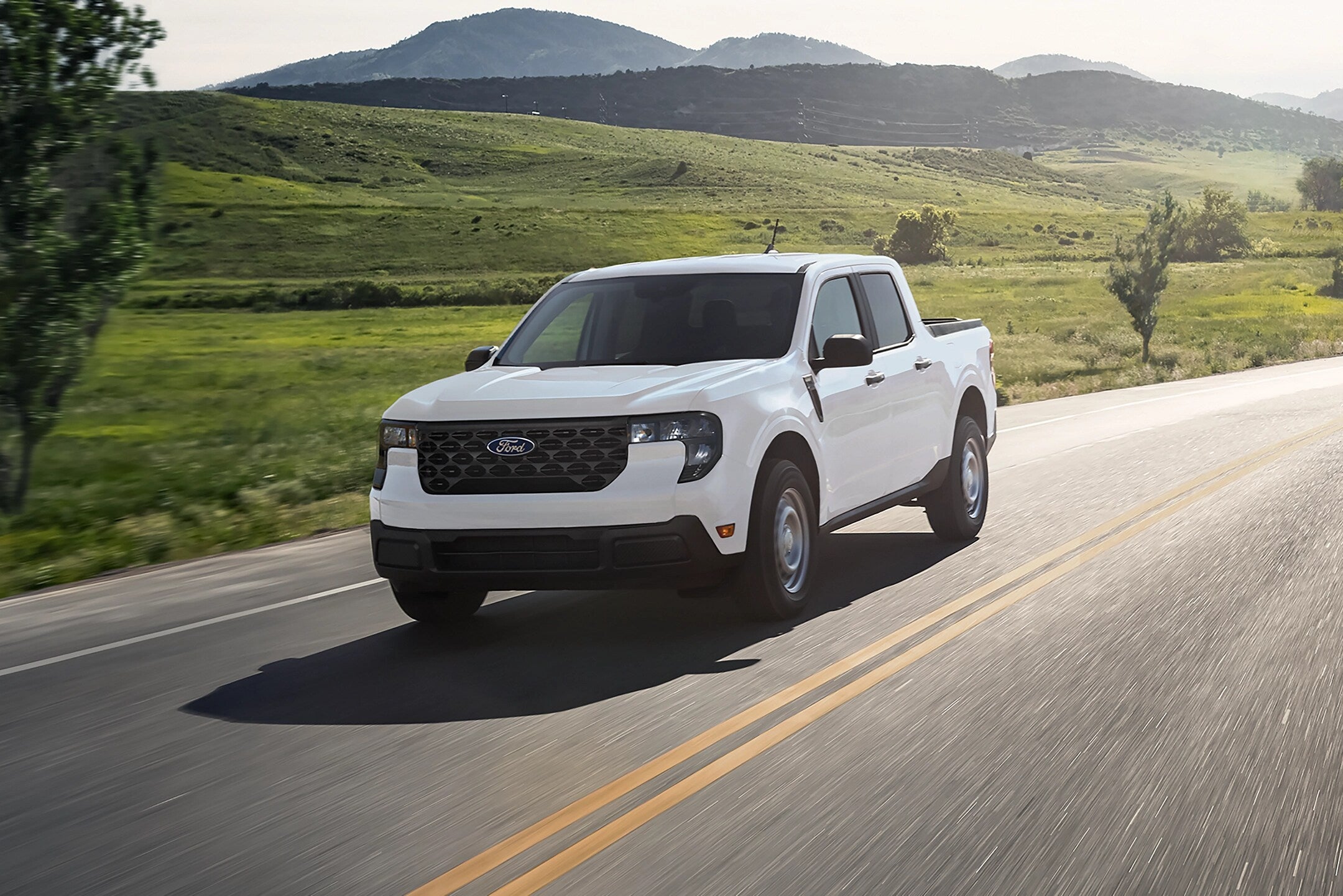 A white truck driving on the road.