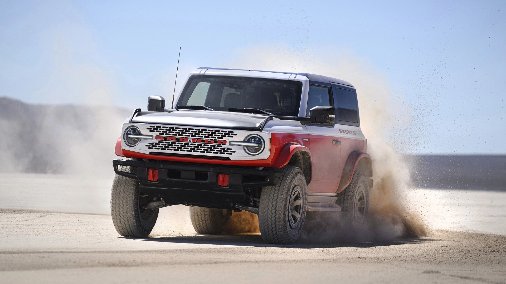 A red and white car driving off-road.