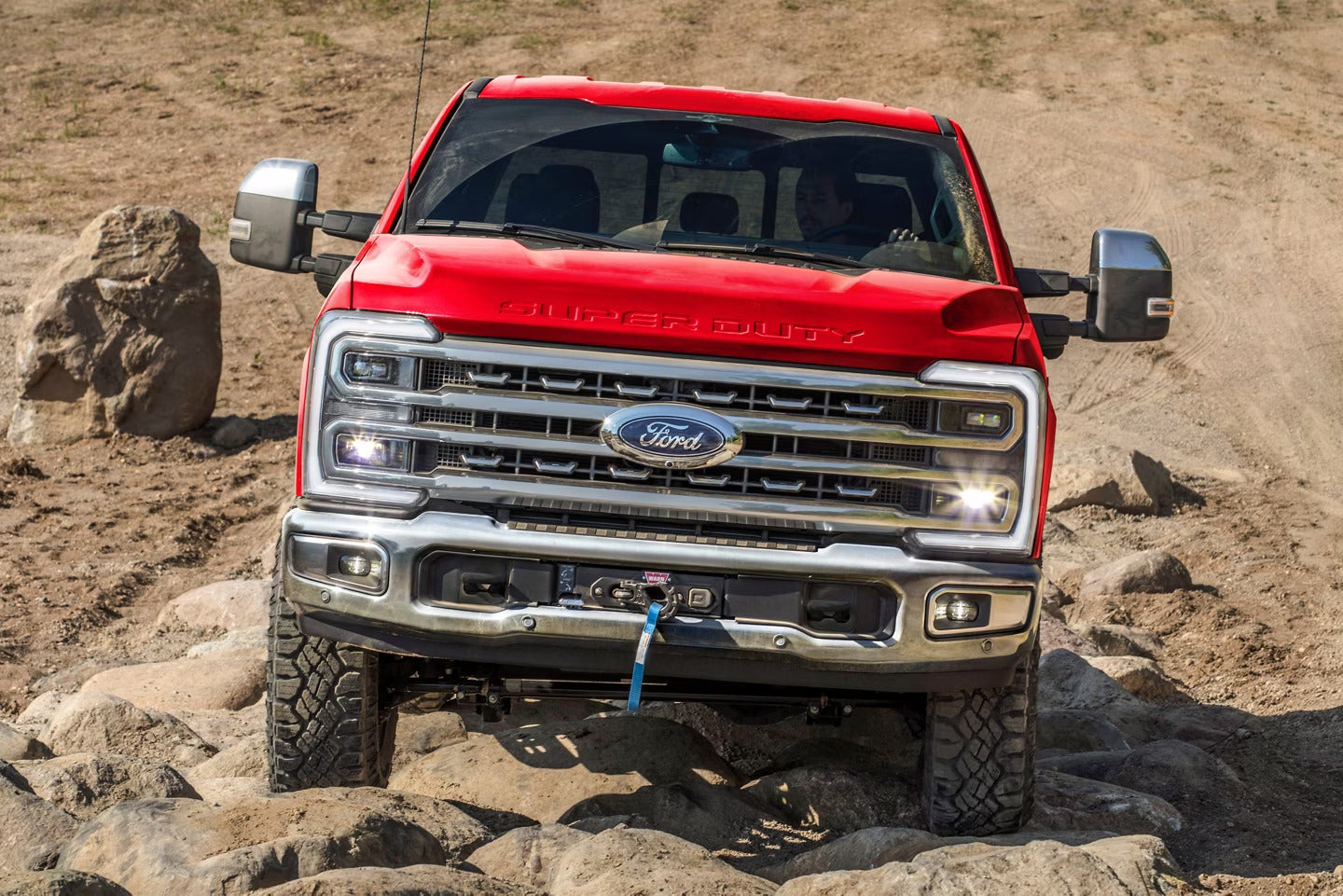 a red ford super duty with showcasing the tremor off-road package on a rocky terrain