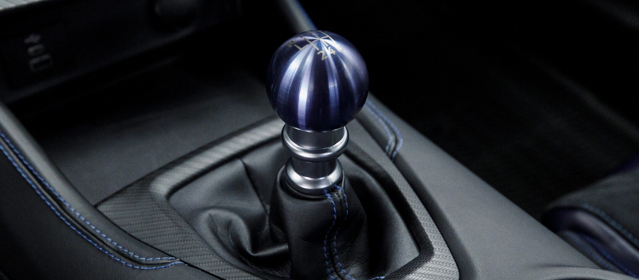 Close-up of a blue metallic gear shifter in the 2025 Ford Mustang, showcasing precise craftsmanship and sporty detail.