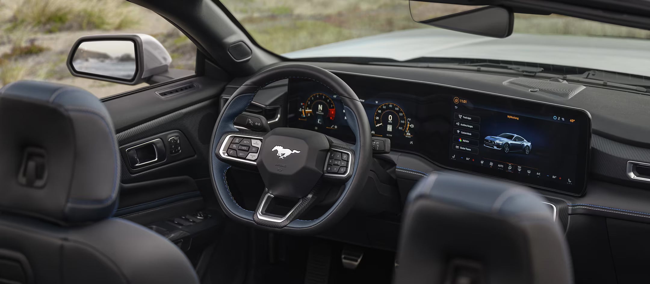 Interior view of the 2025 Ford Mustang dashboard featuring a digital instrument cluster and large infotainment display with Mustang branding on the steering wheel.