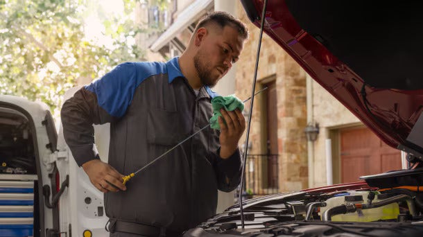 A ford service member performing a oil change 