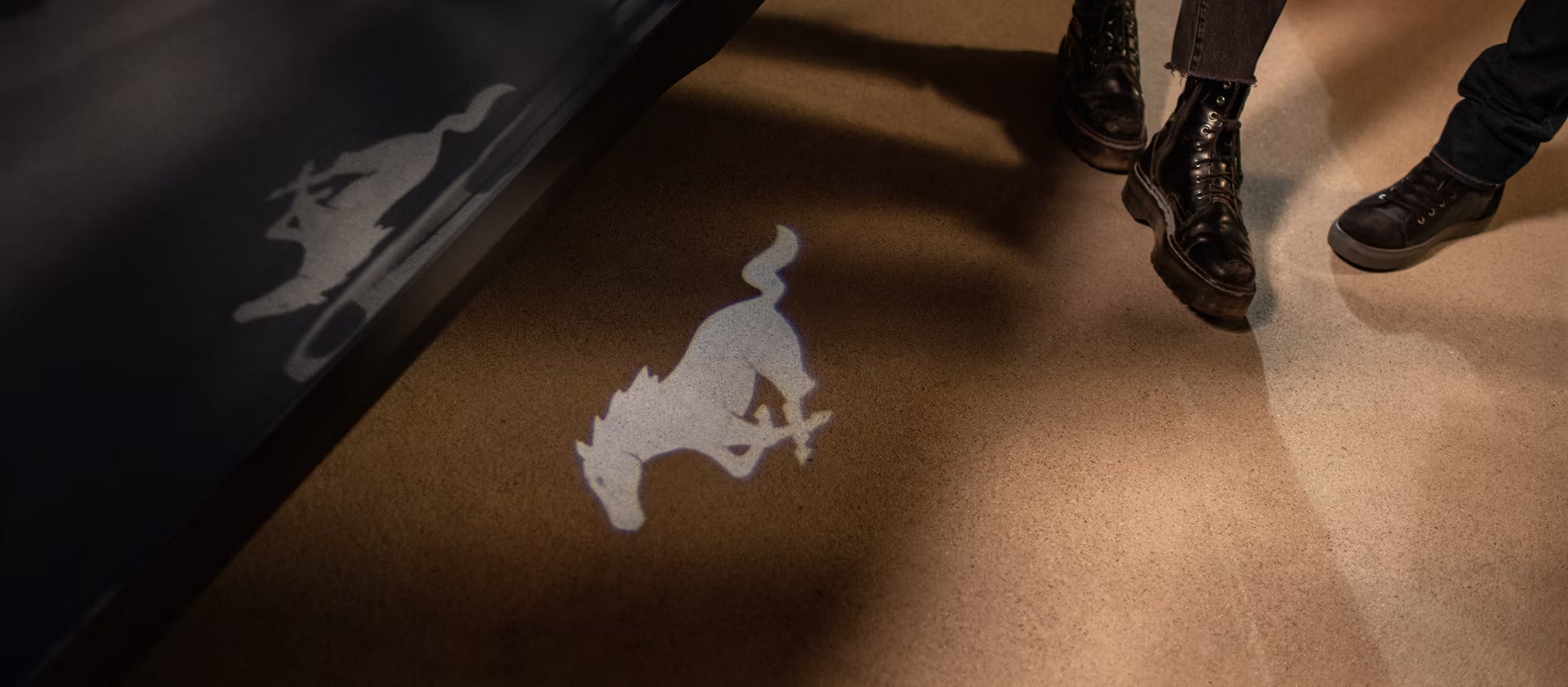 and exterior view of a 2026 Ford Mustang logo shining on the ground