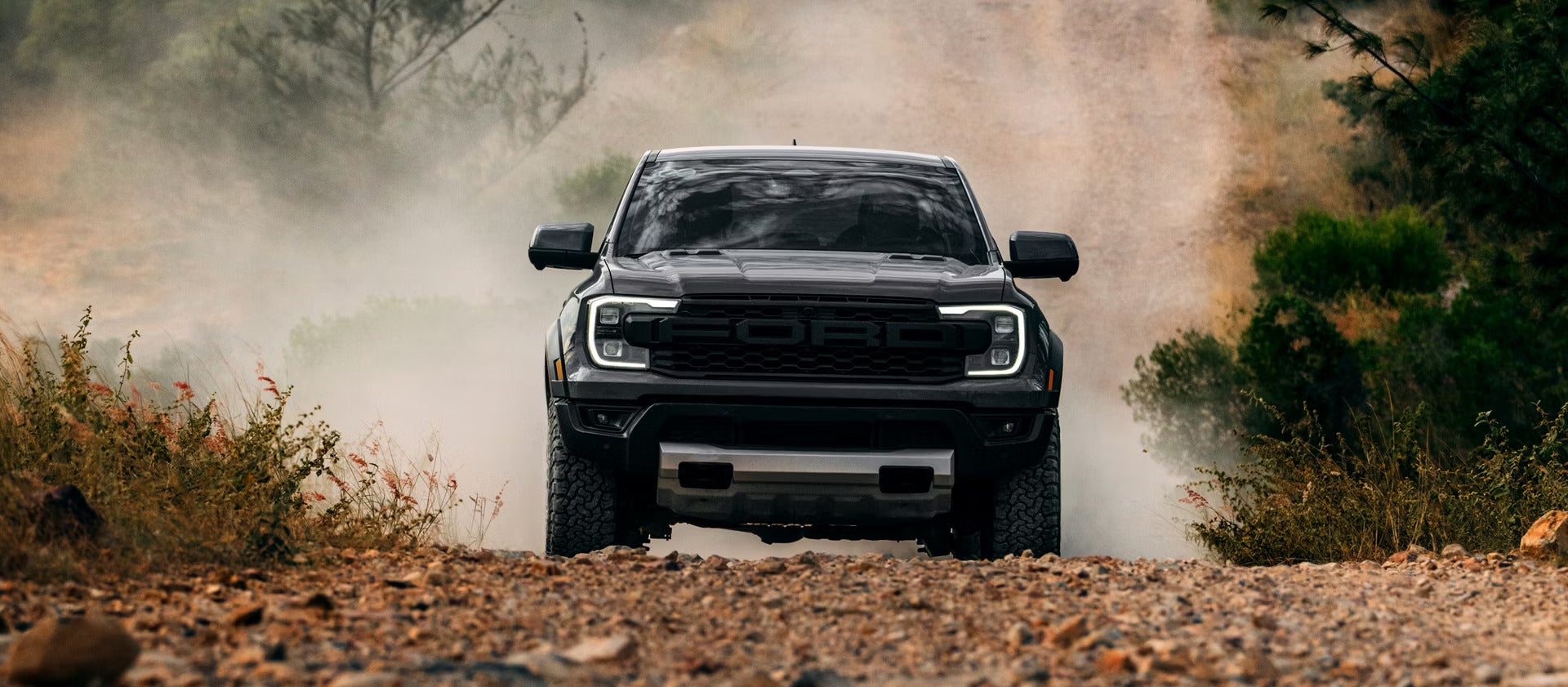 A black ford ranger raptor driving off-road.