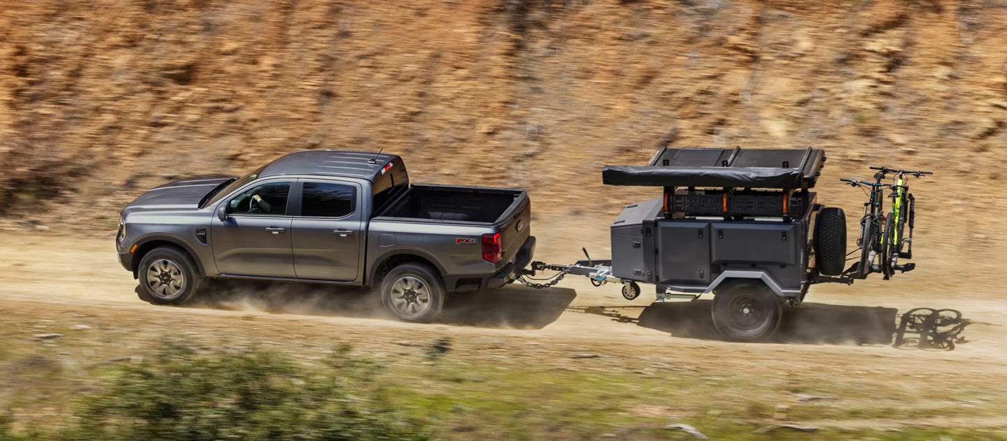 A gray rnager pulling a trailer.