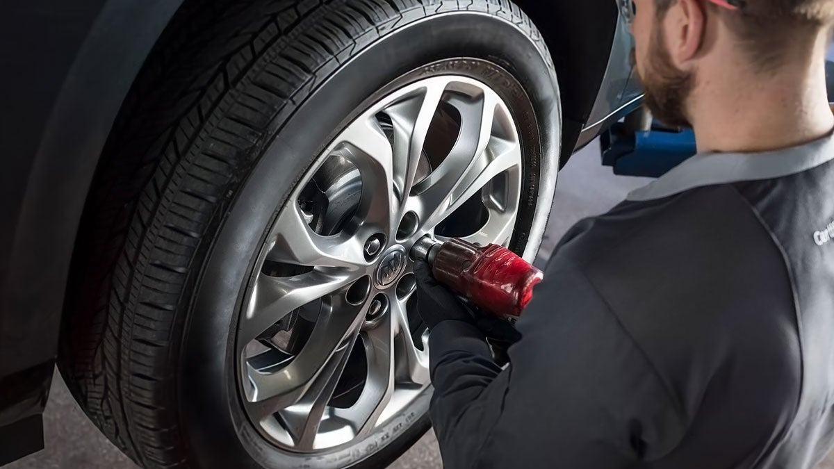A man changing the tire of a car.